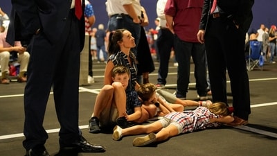 Children wait, lying on the ground before daylight, to attend a memorial service for slain conservative commentator Charlie Kirk at State Farm Stadium, in Glendale, Arizona, U.S., September 21, 2025.  REUTERS/Cheney Orr (REUTERS)