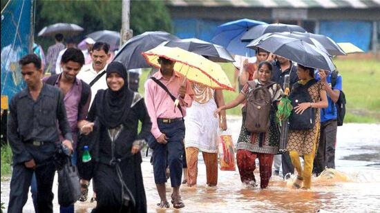 People walk through a flooded road following heavy rains in Mumbai. (PTI Photo/Shashank Parade)