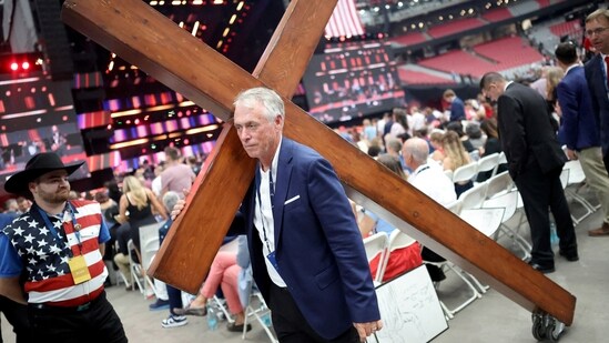 A person carries a cross ahead a memorial service for slain conservative commentator Charlie Kirk at State Farm Stadium, on the day of a memorial service for slain conservative commentator Charlie Kirk, in Glendale, Arizona, U.S., September 21, 2025. REUTERS/Carlos Barria(REUTERS)