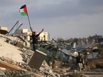 A displaced Palestinian child waves a Palestinian national flag as he stands on the rubble of a destroyed building at the Bureij camp for refugees in the central Gaza Strip A displaced Palestinian child waves a Palestinian national flag as he stands on the rubble of a destroyed building at the Bureij camp for refugees in the central Gaza Strip