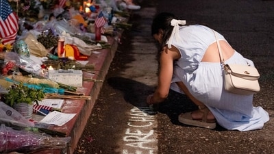A visitor writes "WE ARE CHARLIE" in chalk as she visits a tribute for slain conservative commentator Charlie Kirk at the headquarters of Turning Point USA, in Phoenix, Arizona. (Cheney Orr/REUTERS)