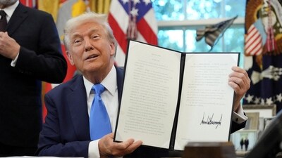 Donald Trump displays a signed executive order on gold card visa in the Oval Office (REUTERS)