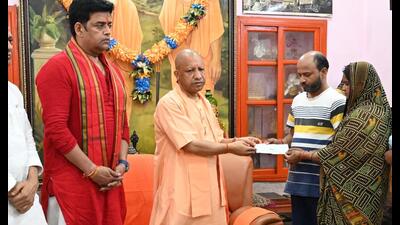 Uttar Pradesh CM Yogi Adityanath giving ₹5 lakh cheque to the parents of the youth killed by cattle smugglers in Gorakhpur. (HT photo) Uttar Pradesh CM Yogi Adityanath giving ₹5 lakh cheque to the parents of the youth killed by cattle smugglers in Gorakhpur. (HT photo)