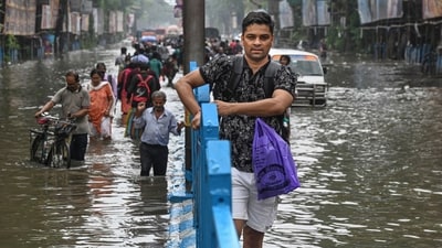 People make their way through a flooded road after heavy rainfall, in Kolkata on Tuesday, September 23 (PTI) People make their way through a flooded road after heavy rainfall, in Kolkata on Tuesday, September 23 (PTI)