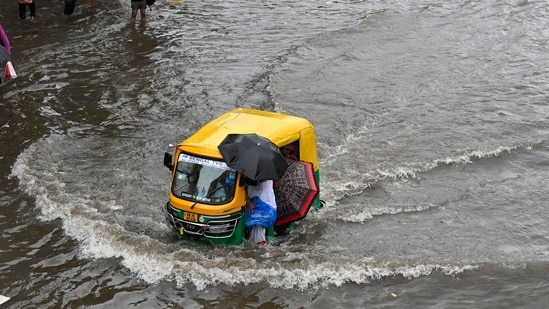 Waves are seen forming on a road in Kolkata as an auto-rickshaw wades through a heavily waterlogged road area.(Samir Jana/Hindustan Times)