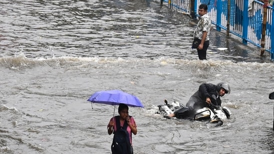 A commuter on a scooter is seen to almost topple as residents face challenges due to incessant rain and waterlogging in Kolkata.(Samir Jana/Hindustan Times)