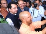 CM Yogi Adityanath sticks a GST handbill at a book store in Lucknow on Wednesday as part of the outreach drive. (HT) CM Yogi Adityanath sticks a GST handbill at a book store in Lucknow on Wednesday as part of the outreach drive. (HT)