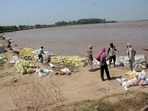 Residents of Sasrali Colony work on strengthening embankment on Wednesday. (HT Photo) Residents of Sasrali Colony work on strengthening embankment on Wednesday. (HT Photo)
