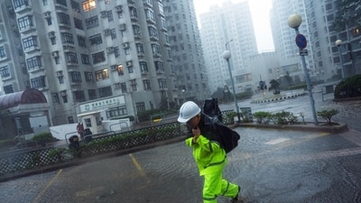 A worker braves the wind while wading through floodwaters in the Heng Fa Chuen residential area during Super Typhoon Ragasa in Hong Kong, China, on Wednesday, Sept. 24, 2025. (Bloomberg)