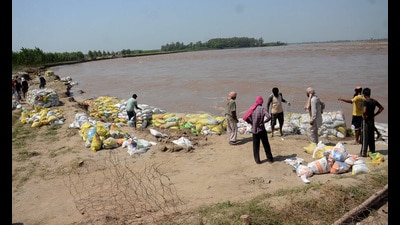 Residents of Sasrali Colony work on strengthening embankment on Wednesday. (HT Photo) Residents of Sasrali Colony work on strengthening embankment on Wednesday. (HT Photo)