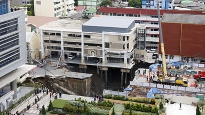 The collapse of the edge of the road in front of a police station left the building's underground construction exposed. (Bloomberg) The collapse of the edge of the road in front of a police station left the building's underground construction exposed. (Bloomberg)