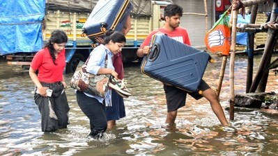 Commuters wade through with their belongings in knee-deep water after streets left waterlogged following overnight heavy rain. (Saikat Paul/ANI) Commuters wade through with their belongings in knee-deep water after streets left waterlogged following overnight heavy rain. (Saikat Paul/ANI)