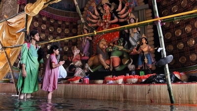 A Durga Puja pandal gets waterlogged after heavy rainfall in Kolkata, with visitors wading to see the idols. (Sudipta Banerjee/ANI) A Durga Puja pandal gets waterlogged after heavy rainfall in Kolkata, with visitors wading to see the idols. (Sudipta Banerjee/ANI)
