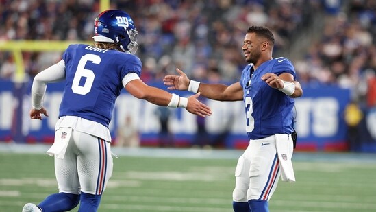 Jaxson Dart #6 of the New York Giants celebrates a touchdown against the New England Patriots with Russell Wilson (Getty Images via AFP)
