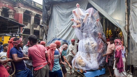 Durga idol wrapped in a plastic sheet to protect it from the rain in Kolkata, amid Durga Puja preparations in the city.(Saikat Paul/ANI)