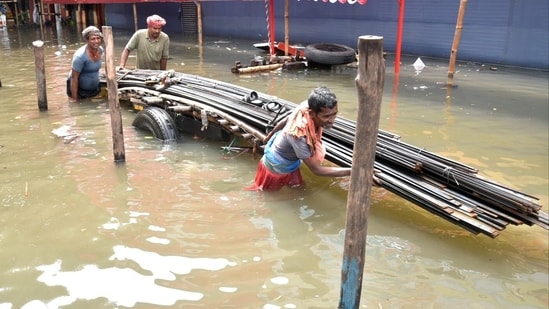 Commuters in Kolkata pull a loaded cart to wade through a waterlogged road, caused by heavy rainfall.(Saikat Paul/ANI)