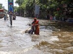 Kolkata: A woman wades through the waterlogged street of south Kolkata due to heavy rainfall, in Kolkata on Wednesday. (ANI Photo)
