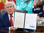President Donald Trump holds a signed presidential memorandum in the Oval Office at the White House.
