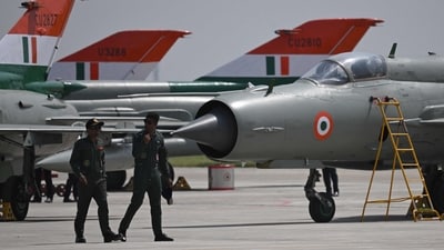 Two IAF officials walk past the MIG-21 Bison fighter jets at Chandigarh Airforce Station on Wednesday, as the country bid farewell to the supersonic fighter jet series today. (Arun Sankar/AFP) Two IAF officials walk past the MIG-21 Bison fighter jets at Chandigarh Airforce Station on Wednesday, as the country bid farewell to the supersonic fighter jet series today. (Arun Sankar/AFP)