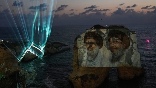 Portraits of former Hezbollah leaders Sayyed Hassan Nasrallah, right, and Hashem Safieddine, are projected onto the landmark Raouche sea rock during an event commemorating the anniversary of their assassination, in Beirut, Lebanon, Thursday, Sept. 25, 2025. (AP Photo/Hussein Malla) (AP)