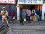 An Indo-Tibetan Border Police (ITBP) personnel stands guard as locals crowd a convenience store after curfew was partially relaxed for a few hours in Leh on September 27, 2025. 