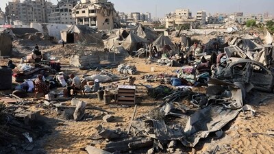 Displaced Palestinians check what remains of their tents, following an overnight Israeli strike that levelled a building and damaged the surrounding temporary shelters, in the Rimal neighbourhood of Gaza City. (Omar al-Qattaa/AFP) Displaced Palestinians check what remains of their tents, following an overnight Israeli strike that levelled a building and damaged the surrounding temporary shelters, in the Rimal neighbourhood of Gaza City. (Omar al-Qattaa/AFP)
