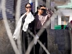 A woman pays her respects and another looks on as mortal remains of 24-year-old Stanzin Namgyal, who was killed in violence during recent protests for Ladakh statehood, are being taken for last rites amid curfew in Leh on Sunday, September 28, 2025.