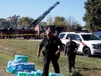 Law enforcement officers work near the burnt Church of Jesus Christ of Latter-day Saints, after a shooting and a fire took place