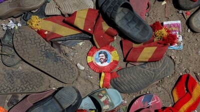 A badge with a picture of Vijay, actor and politician, lies amid footwear and other belongings left by attendees at the site of a stampede incident&nbsp; (Reuters)