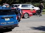 An FBI agent holds a long gun that was removed from the car of a man detained near the scene of a shooting which took place at the Church of Jesus Christ of Latter-day Saints, in Grand Blanc, Michigan, U.S., September 29, 2025. REUTERS/Rebecca Cook REFILE - CORRECTING FROM "POLICE OFFICER" TO "FBI AGENT".