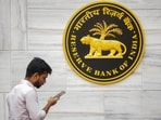 A man walks past the RBI logo at RBI headquarters in Mumbai. A man walks past the RBI logo at RBI headquarters in Mumbai.