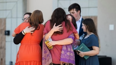 People are reunited at Trillium NCG Theatre with friends and family who were present during a nearby shooting and structure fire at The Church of Jesus Christ of Latter-day Saints on McCandlish Road in Grand Blanc, Mich., Sunday, Sept. 28, 2025. (Katy Kildee/Detroit News via AP) (AP) People are reunited at Trillium NCG Theatre with friends and family who were present during a nearby shooting and structure fire at The Church of Jesus Christ of Latter-day Saints on McCandlish Road in Grand Blanc, Mich., Sunday, Sept. 28, 2025. (Katy Kildee/Detroit News via AP) (AP)