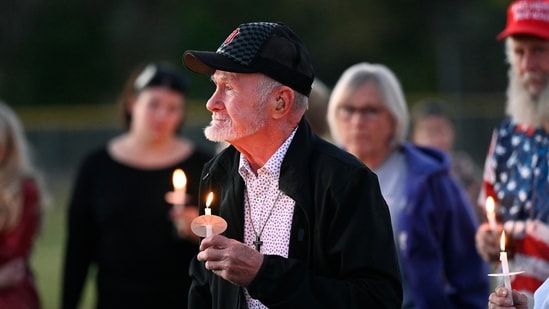 Attendees hold their lit candles during a vigil after a nearby church shooting held at Holy Redeemer Church in Burton, Mich., Sunday, Sept. 28, 2025. (AP Photo/Jose Juarez)(AP)