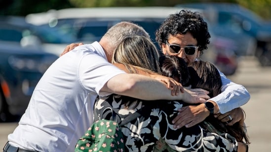 A family emotionally reunites at the Trillium Theater located across the street from the site of a shooting and fire at the Church of Jesus Christ of Latter-day Saints on September 28, 2025 in Grand Blanc, Michigan.&nbsp;(Getty Images via AFP)