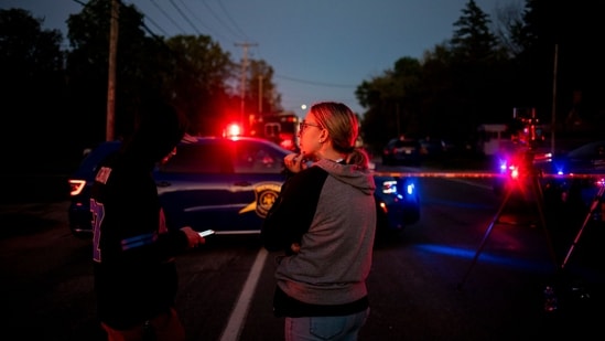 Bystanders observe the Michigan State Police Bomb Squad work outside a shooting suspect's residence on September 28, 2025 in Burton, Michigan.&nbsp;(Getty Images via AFP)