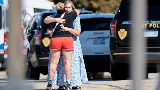 People embrace near the scene of a shooting at a church in Grand Blanc, Michigan, on September 28, 2025.&nbsp;(AFP)