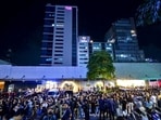 Call center employees surf mobile phones as they gather outside their office building after earthquake tremors at Cebu in central Philippines on September 30, 2025. (Photo by Alan TANGCAWAN / AFP)