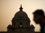 A commuter walks past the building of India's Ministry of Finance during dusk in New Delhi.