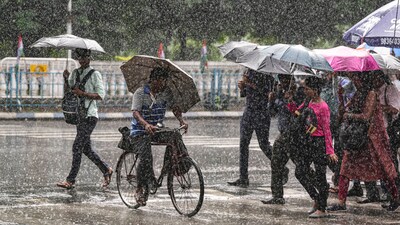 Commuters protect themselves from heavy rainfall in Bengaluru. (PTI)