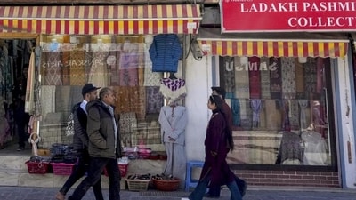 People walk past shops at a market during relaxation in the curfew in Leh on Tuesday, Sept 30. (PTI)