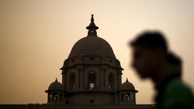 A commuter walks past the building of India's Ministry of Finance during dusk in New Delhi. (Reuters)