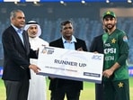Mohsin Naqvi awards Salman Ali Agha the runners-up cheque from the Asia Cup.