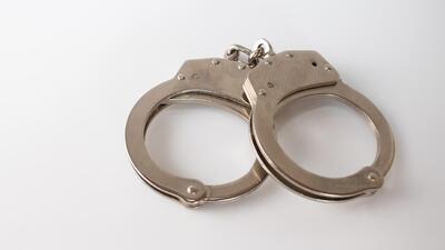 A high angle shot of metal handcuffs isolated on a white background