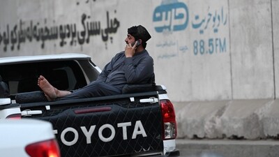 An Afghan man speaks on a mobile phone as he sits on the boot of a vehicle in Kabul on October 1, 2025. (Photo by Wakil KOHSAR / AFP) (AFP) An Afghan man speaks on a mobile phone as he sits on the boot of a vehicle in Kabul on October 1, 2025. (Photo by Wakil KOHSAR / AFP) (AFP)