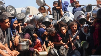 Palestinian women and children wait to receive food portions from a charity kitchen in Khan Yunis in the southern Gaza Strip. (AFP) Palestinian women and children wait to receive food portions from a charity kitchen in Khan Yunis in the southern Gaza Strip. (AFP)