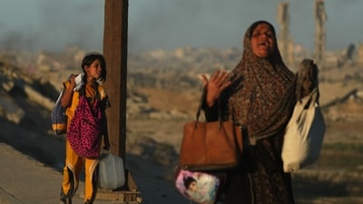 Displaced Palestinians flee northern Gaza carrying their belongings along the coastal road near Wadi Gaza, on Wednesday, October 1, 2025. (AP) Displaced Palestinians flee northern Gaza carrying their belongings along the coastal road near Wadi Gaza, on Wednesday, October 1, 2025. (AP)
