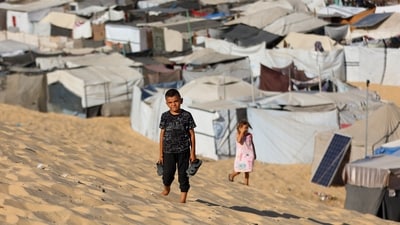 Children walk at a camp for displaced Palestinians in Khan Yunis in the southern Gaza Strip, on September 29, 2025, amid the ongoing conflict between Israel and the Palestinian militant group Hamas. (Photo by Omar AL-QATTAA / AFP) (AFP)
