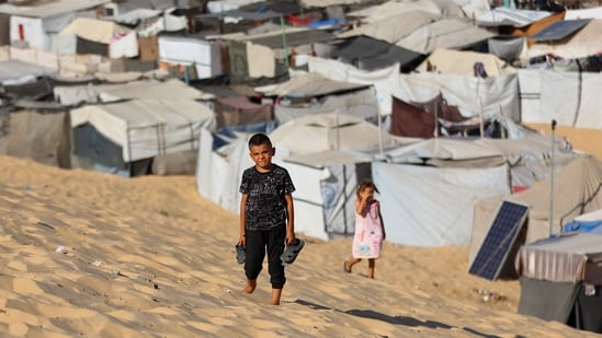 Children walk at a camp for displaced Palestinians in Khan Yunis in the southern Gaza Strip, on September 29, 2025, amid the ongoing conflict between Israel and the Palestinian militant group Hamas. (Photo by Omar AL-QATTAA / AFP) (AFP)