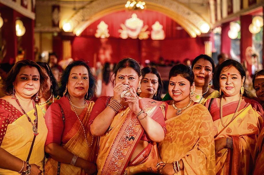 Dressed in traditional laal paar sarees, women blow a conch to announce the arrival of Maa Durga at one of CR Park’s many pandals. (Photo: Raj K Raj/HT) Dressed in traditional laal paar sarees, women blow a conch to announce the arrival of Maa Durga at one of CR Park’s many pandals. (Photo: Raj K Raj/HT)