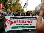Protesters hold a banner with the colours of the Palestinian flag which reads "Against Zionism and all forms of colonialism, Resistance until liberation" 